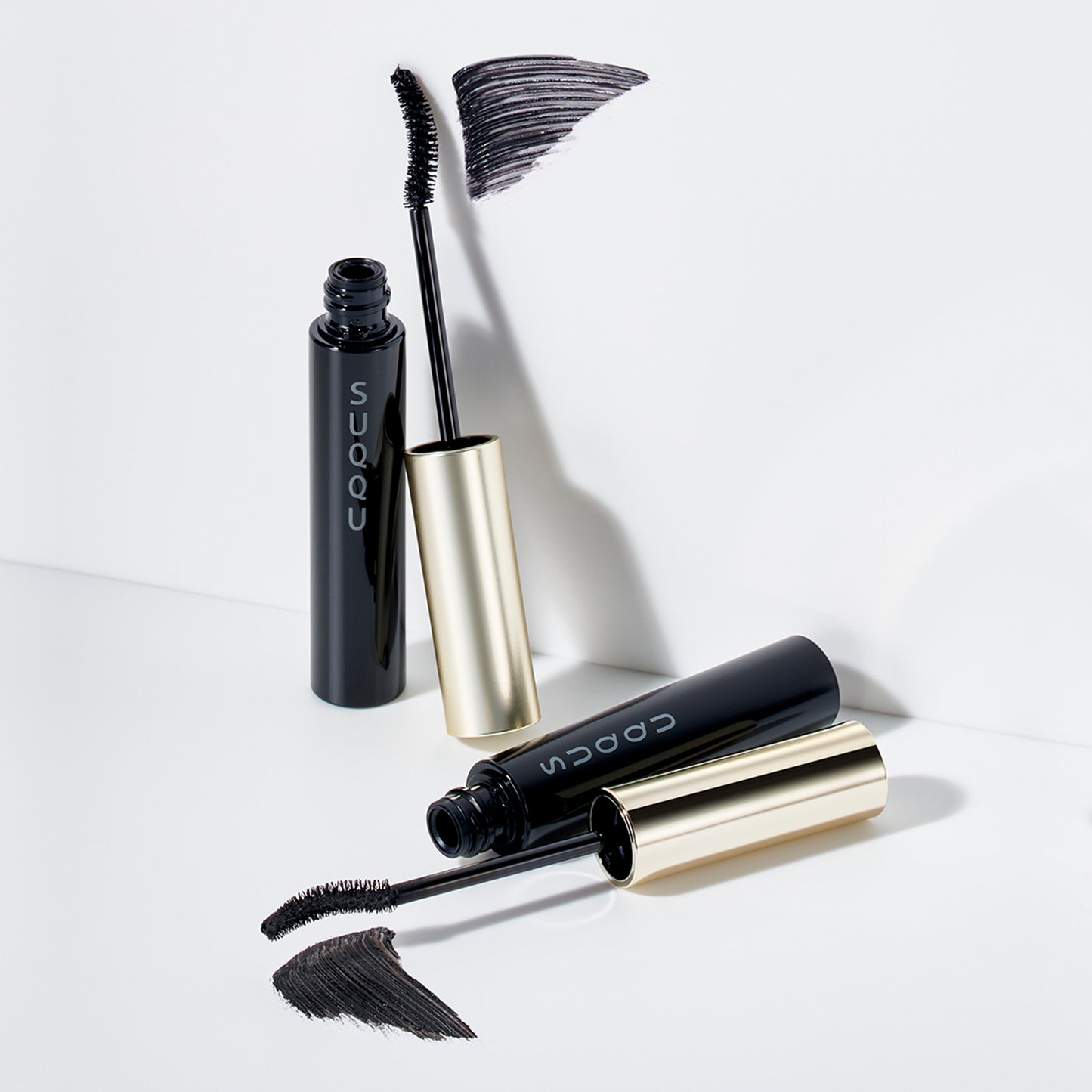 Black SUQQU Eyelash Mascara and Waterproof with wand and swatch. Airy, clump-free separation and longer lashes.