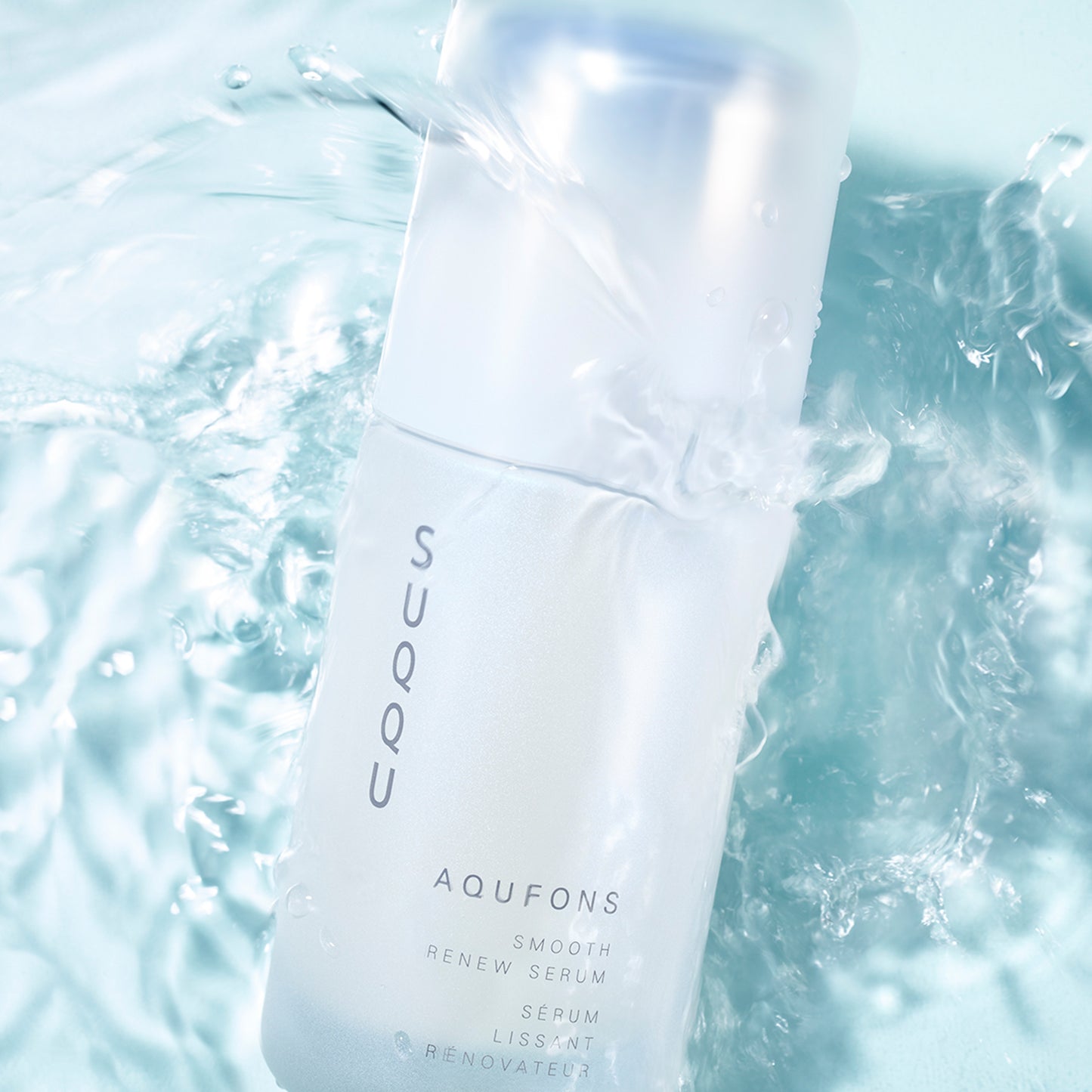 SUQQU Aqufons Smooth Renew Serum skincare bottle floating in water.