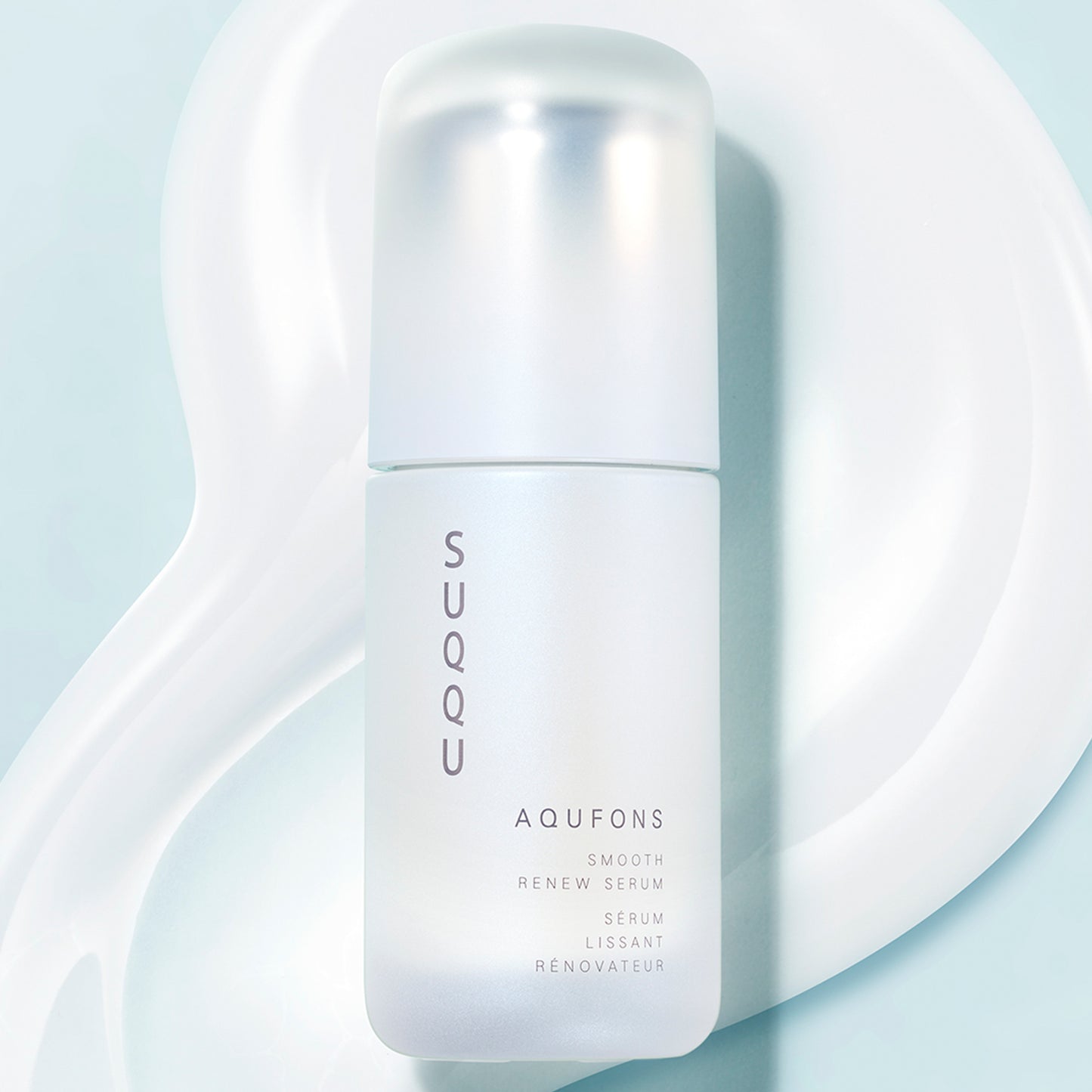 SUQQU Aqufons Smooth Renew Serum skincare bottle with creamy texture background.