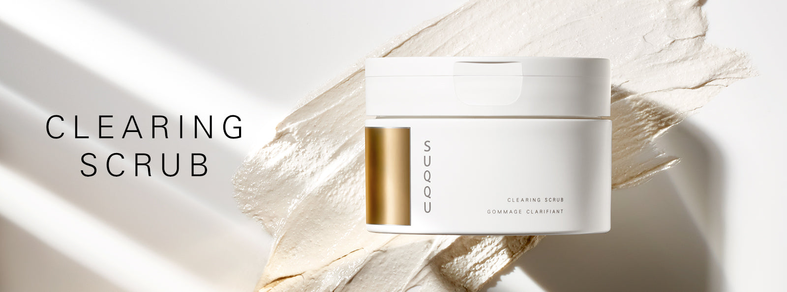 SUQQU Clearing Scrub face cleanser tub with texture swatch background