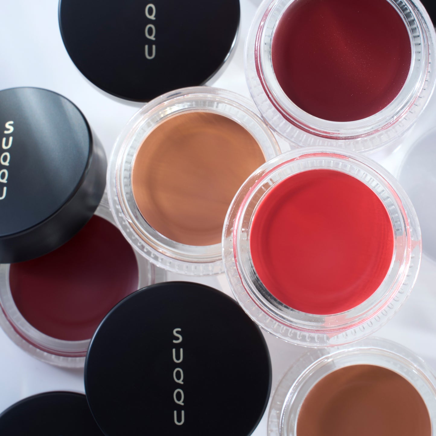 Five shades of SUQQU Cream Touch Blush and Lip products open pots