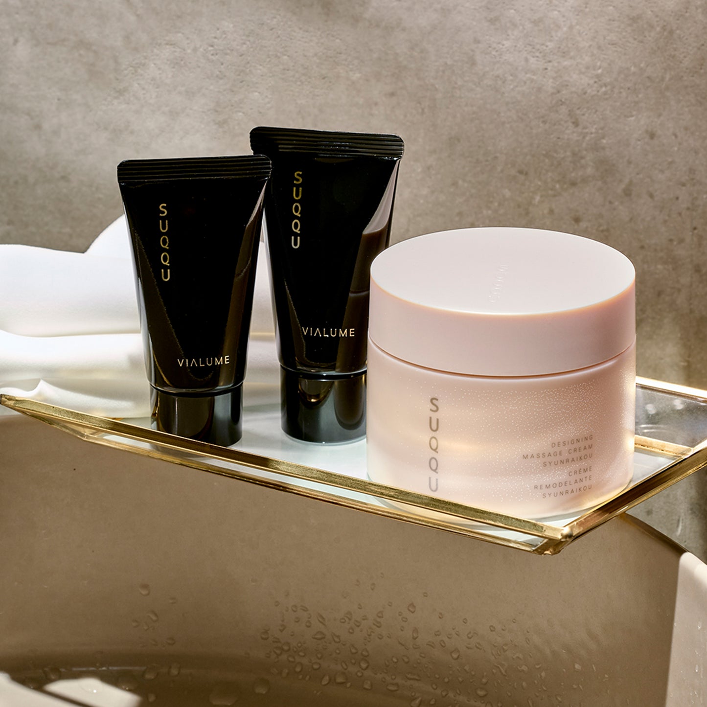 SUQQU Designing Massage Cream Kit Syunraikou products in bathroom with towel.