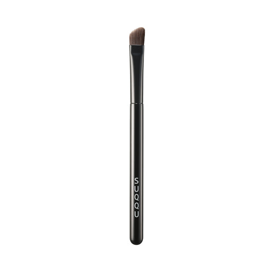 SUQQU Eyebrow Brush Large Japanese synthetic artisan professional grade make up brush on plain background.