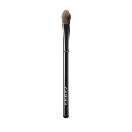 SUQQU Eyeshadow Brush F Large Japanese synthetic artisan professional grade make up brush on plain background.