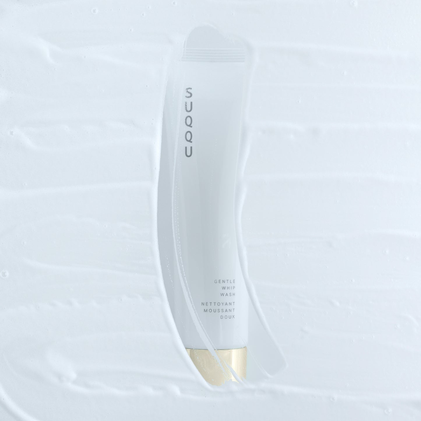 SUQQU Gentle Whip Wash foaming face cleansing skincare product tube with foamy foreground.