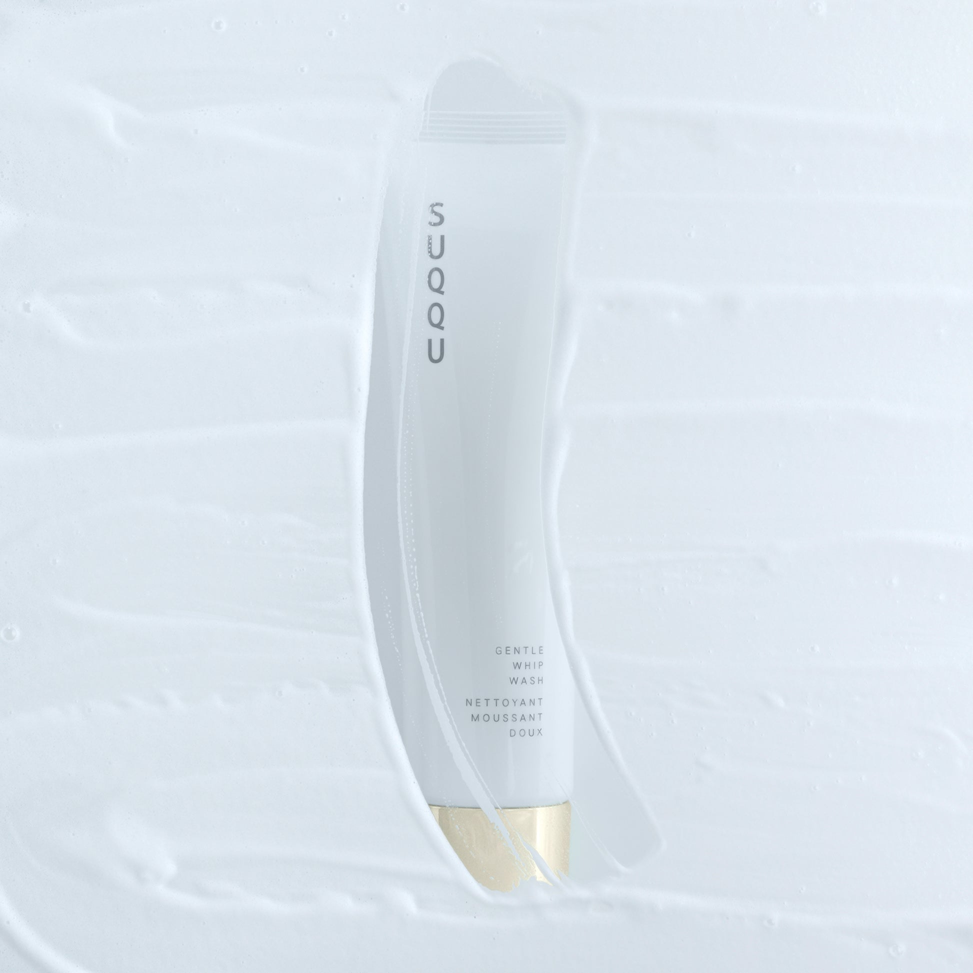 SUQQU Gentle Whip Wash foaming face cleansing skincare product tube with foamy foreground.