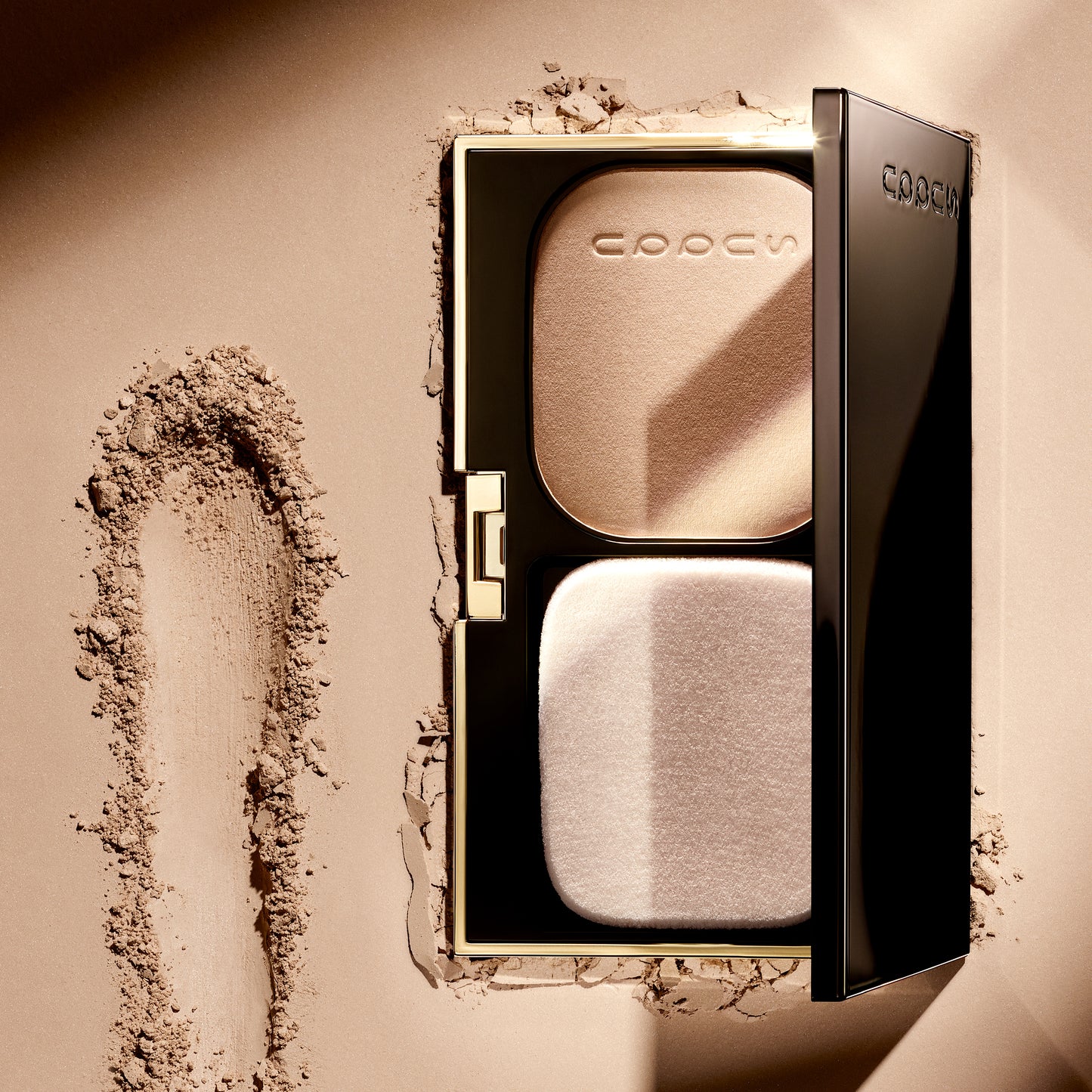 SUQQU Glow Powder Foundation base make up pan and compact shown on textured background.