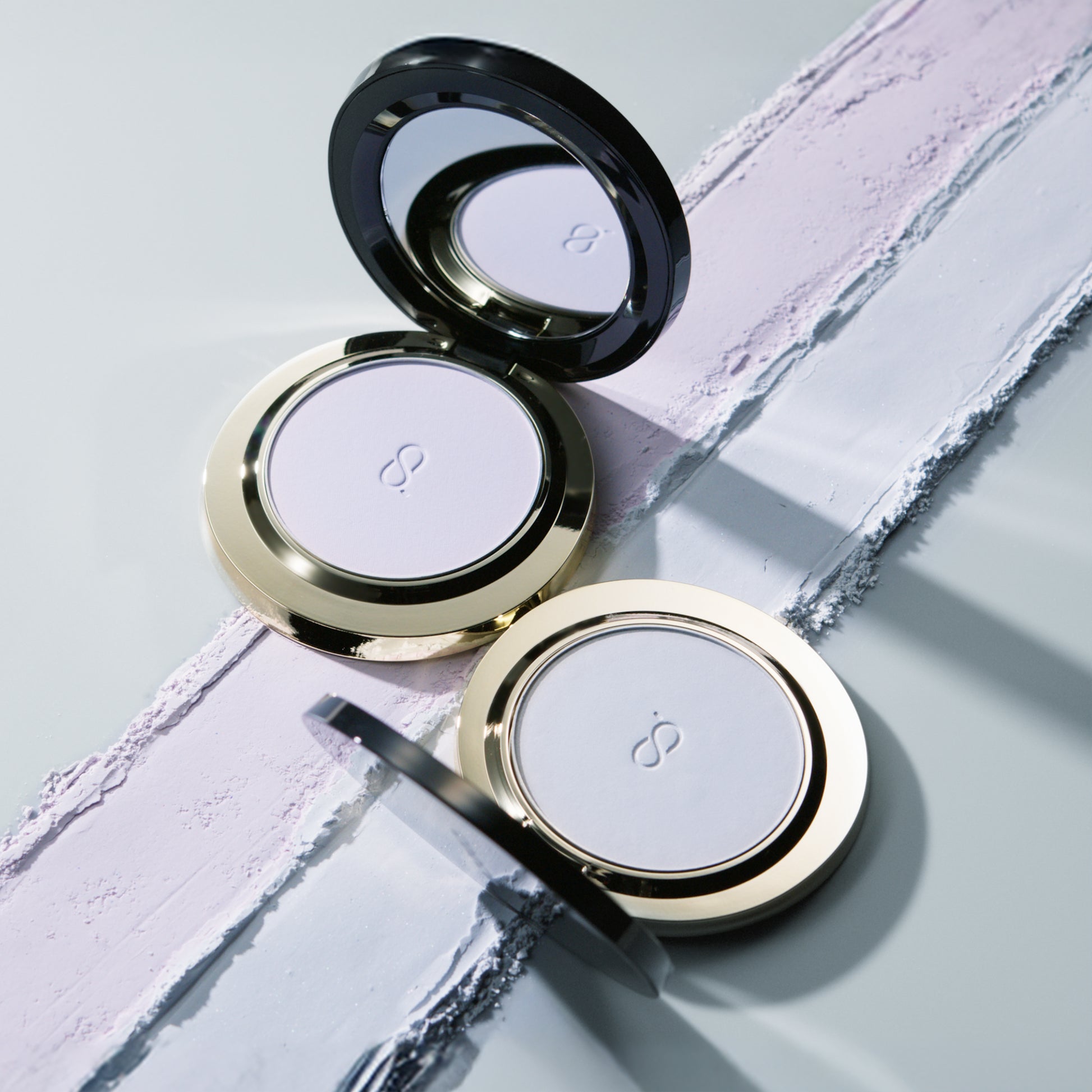 Two SUQQU Setting Powder Compacts open with texture background