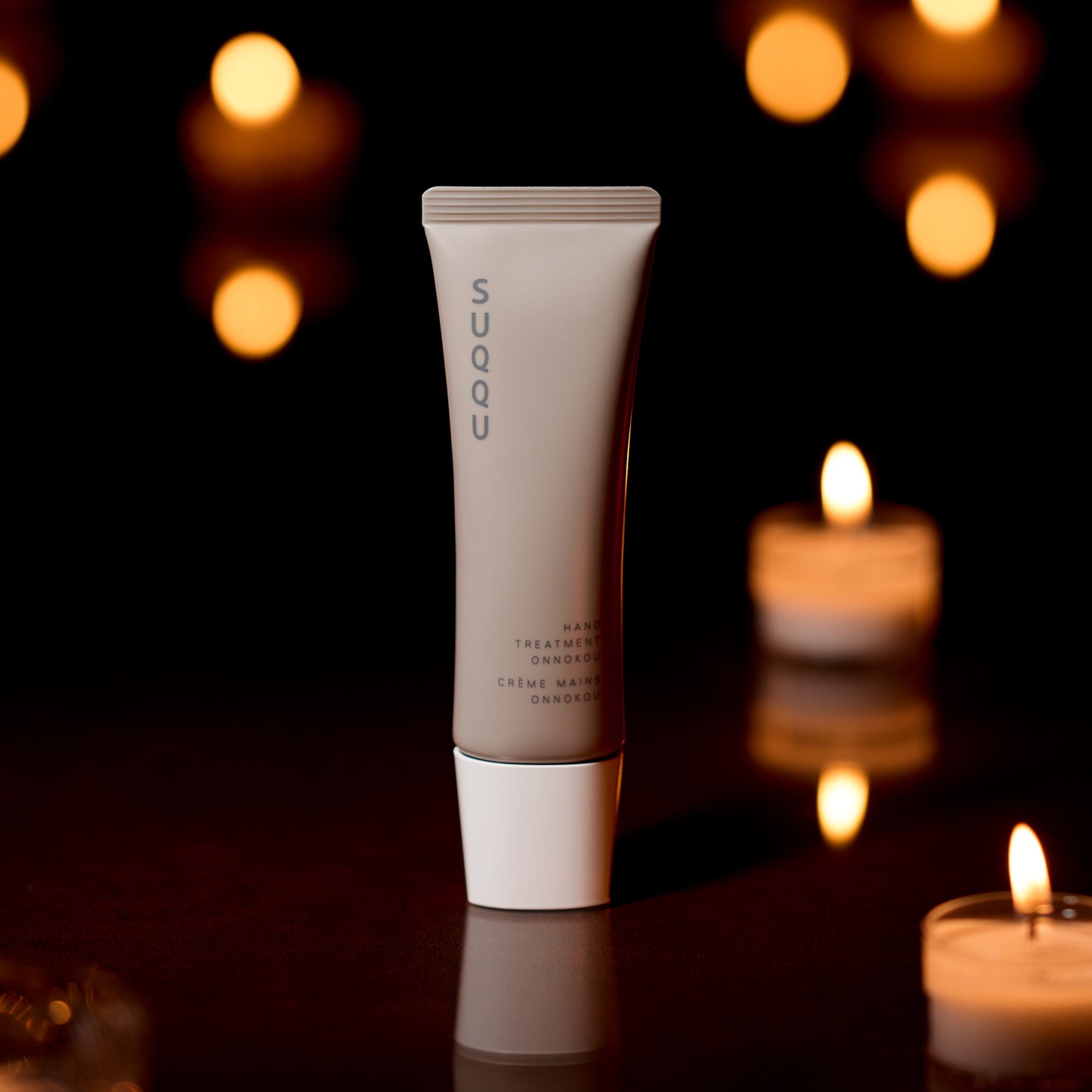 SUQQU Hand Treatment Onnokou Japanese scented moisturising hand cream product on dark background.