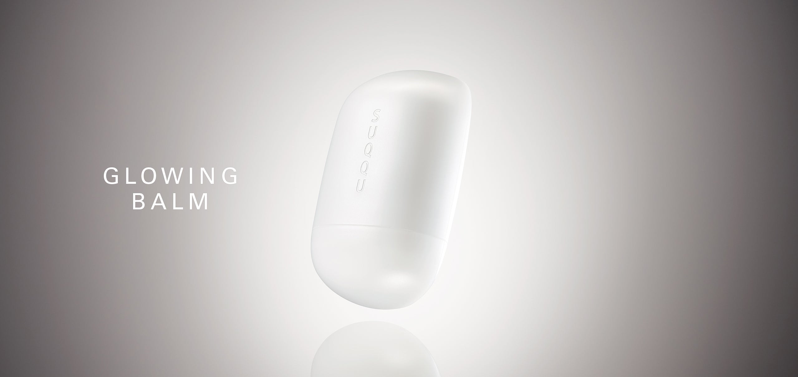 SUQQU Glowing Balm product floating on a soft grey background with product name.