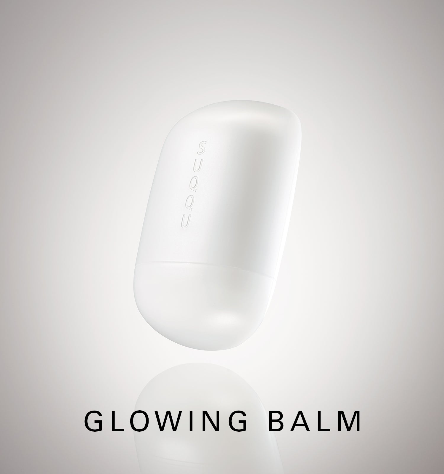 SUQQU Glowing Balm product floating on a soft grey background with product name.