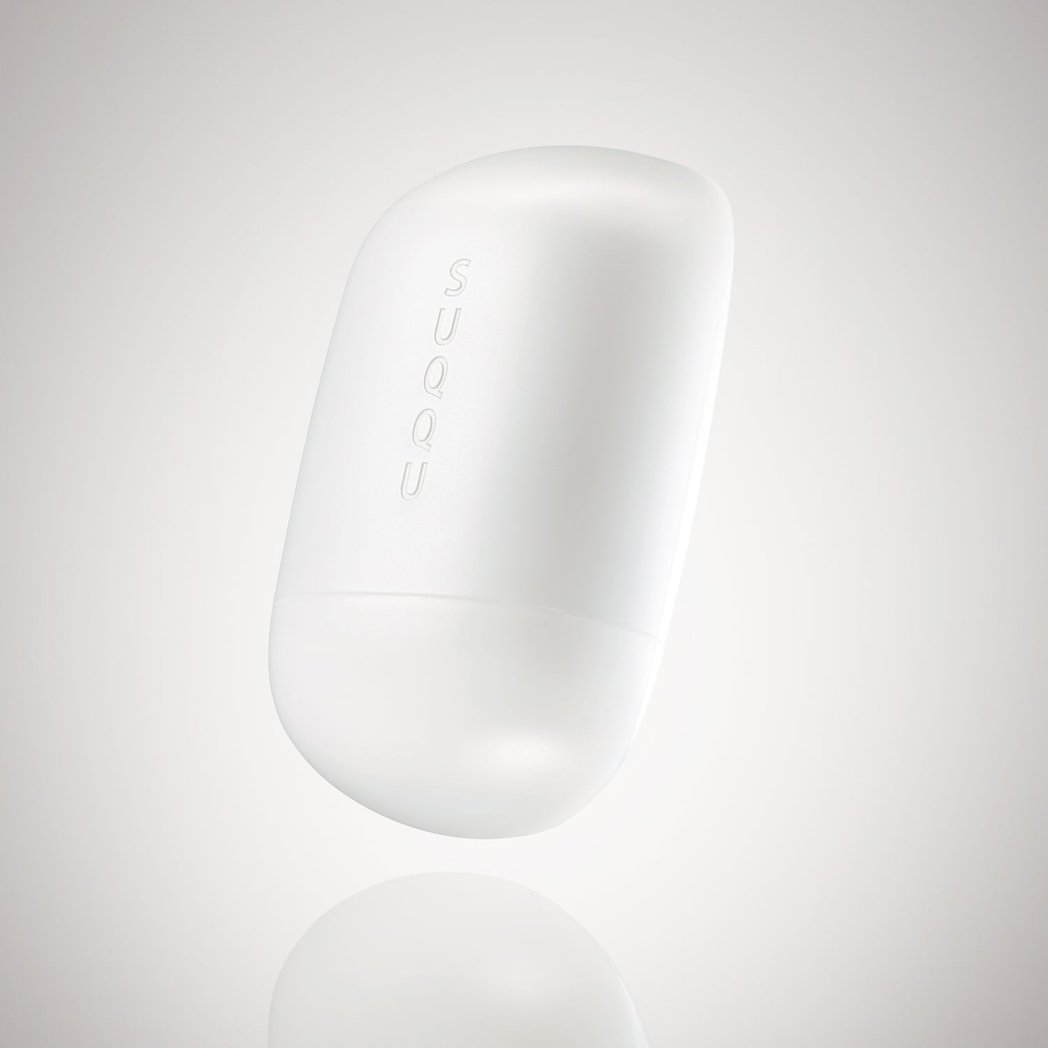 SUQQU Glowing Balm product floating on a soft grey background.