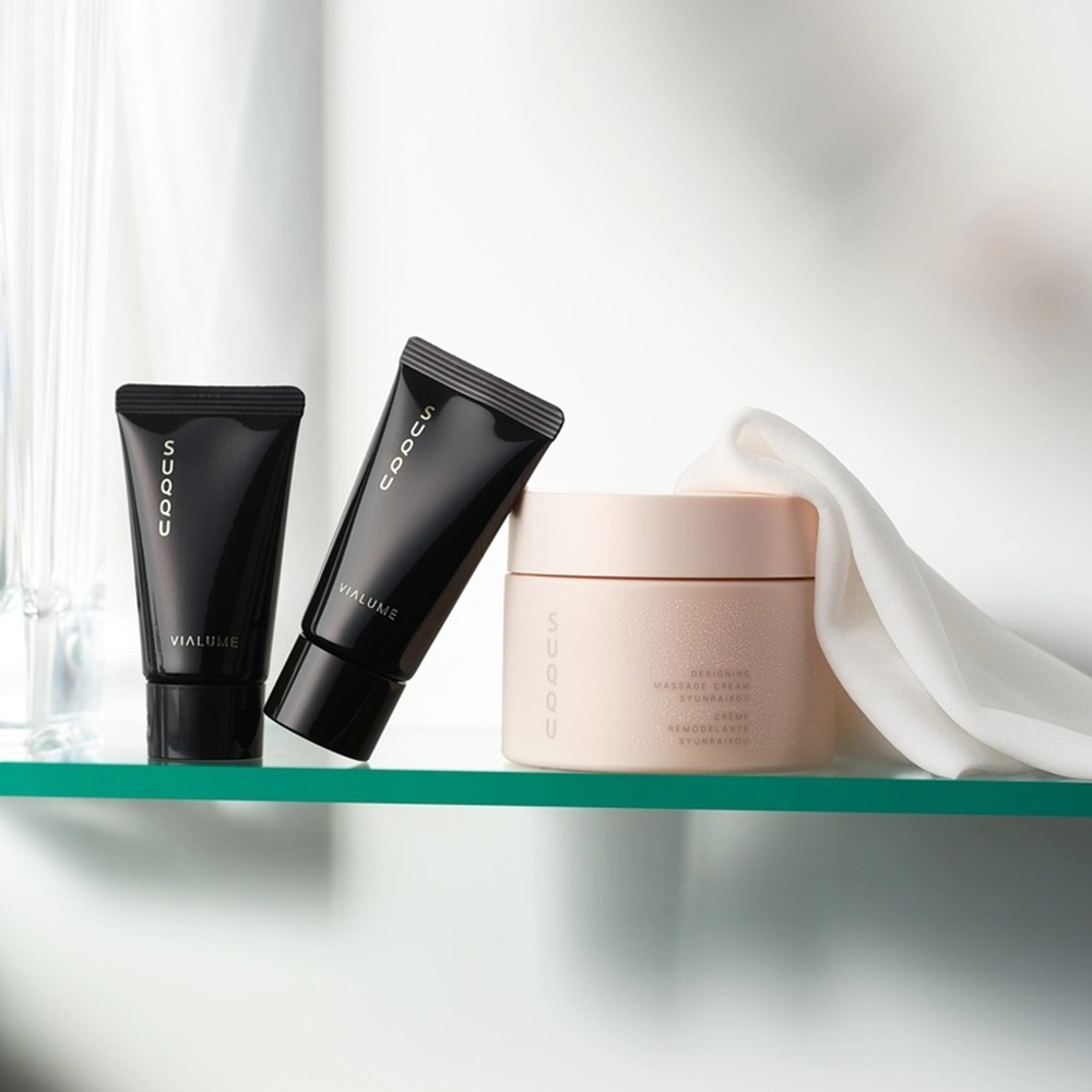 SUQQU Designing Massage Cream "Syunraikou" skincare product tub with other skincare products