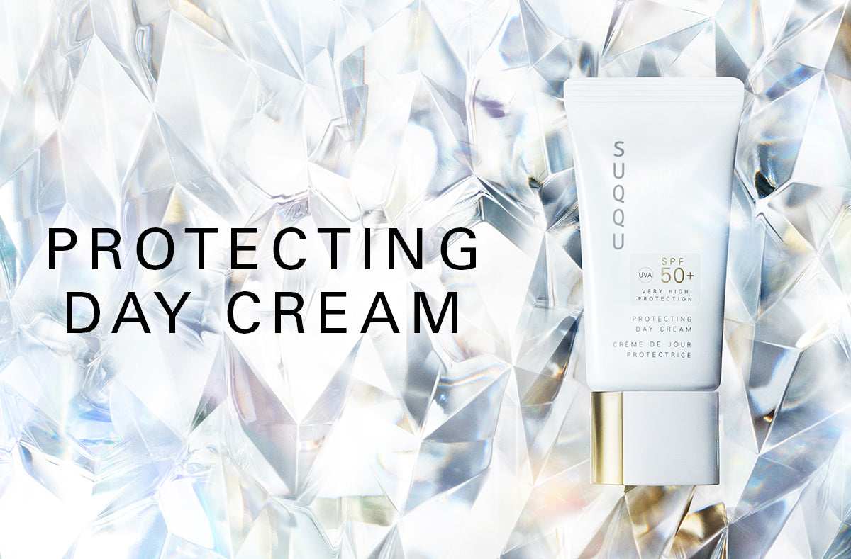 SUQQU Protecting Day Cream Japanese best luxury sunscreen SPF 50+ with moisturising skincare for face. UV-A, UV-B protecting skincare and base makeup product tube on crystal background.