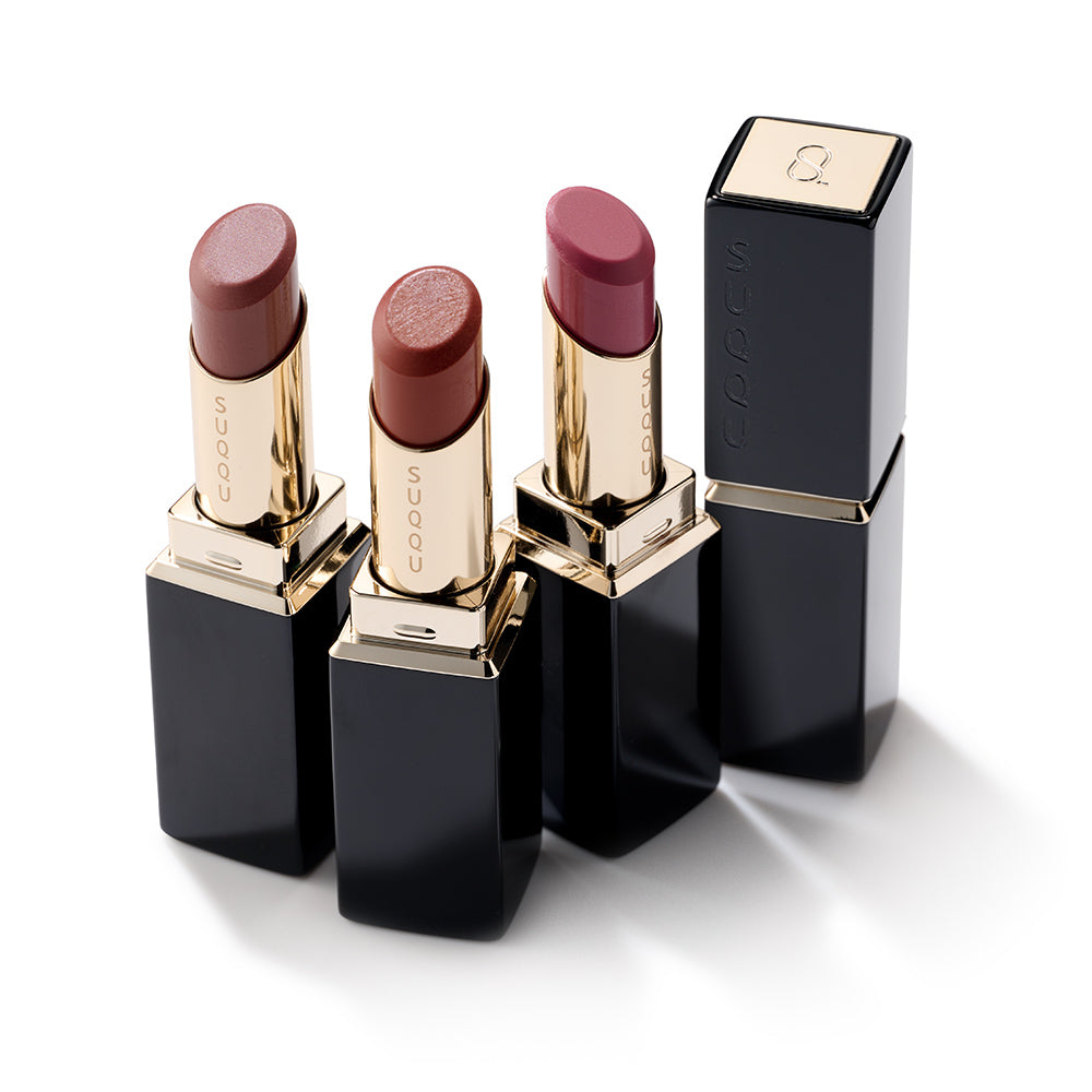 Three open Moisture Glaze Lipstick colour make up products on a table with closed case.
