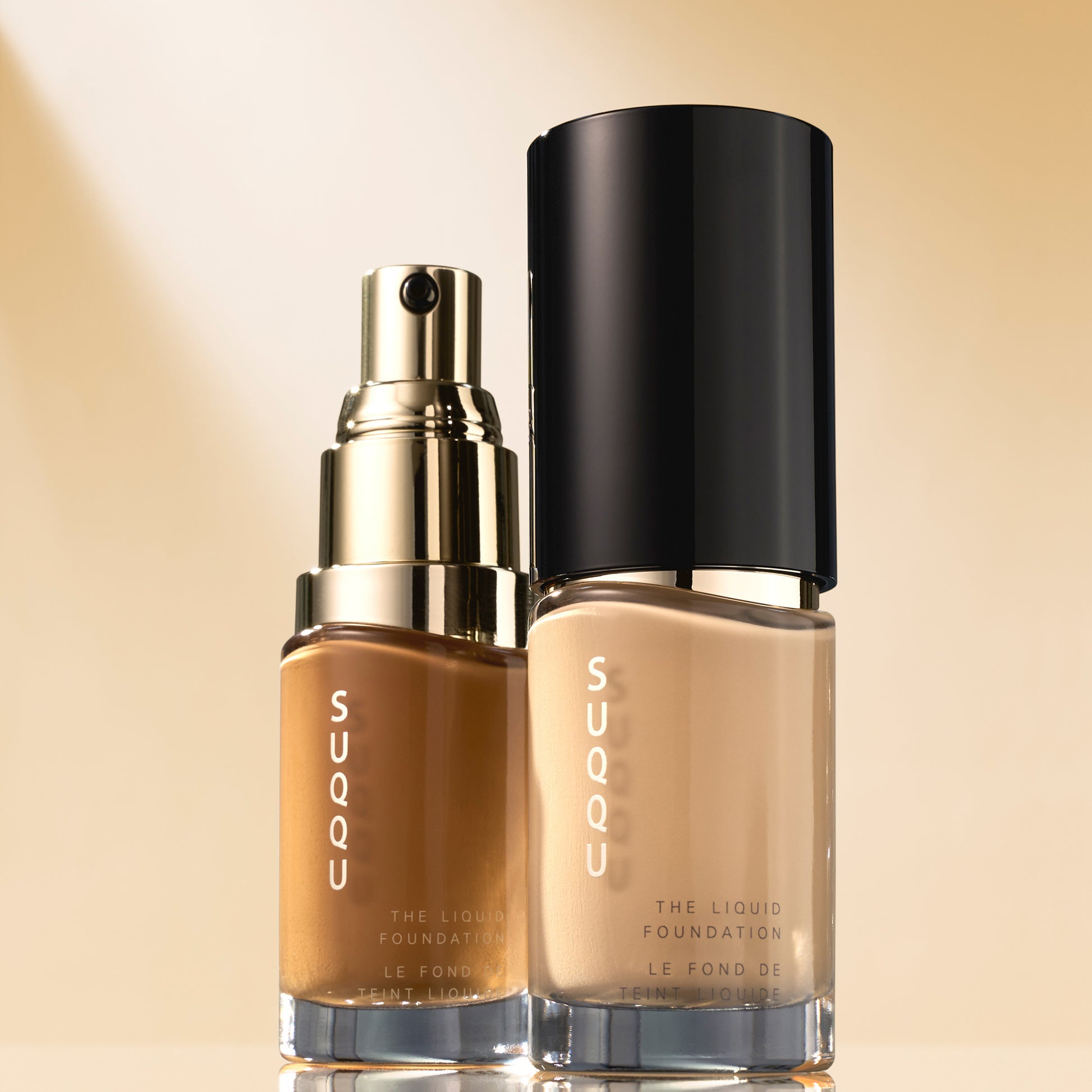 Two bottles of SUQQU The Liquid Foundation with cap on and off showing pump.