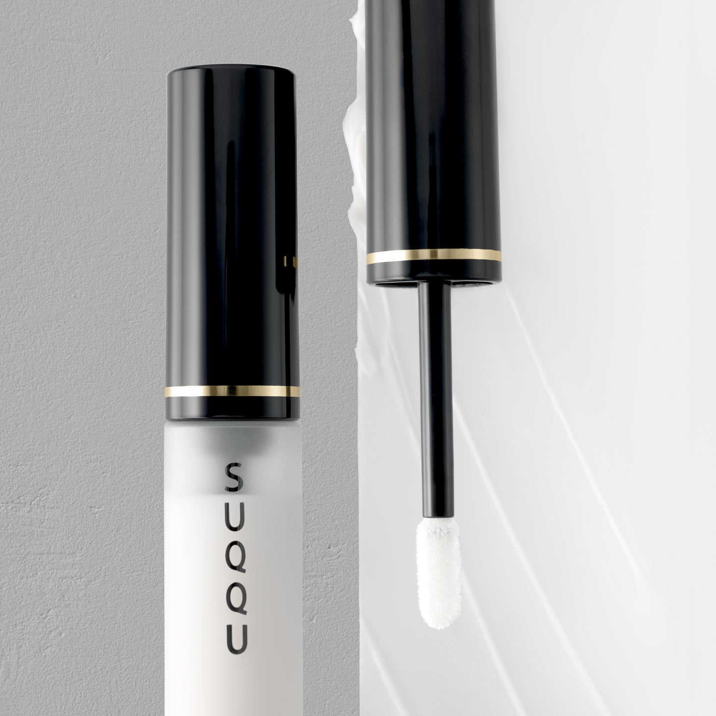 SUQQU Eye Enhancing Primer eye make up product open with wand on texture background.