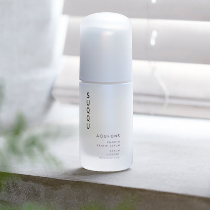 SUQQU Aqufons Smooth Renew Serum skincare bottle on window sill.