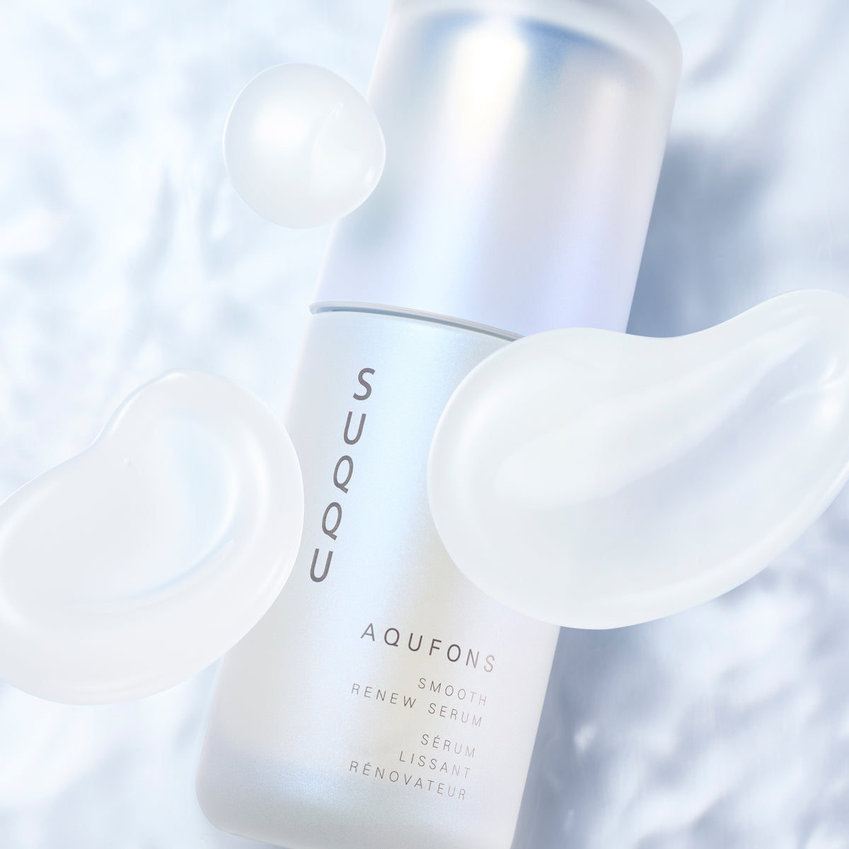 SUQQU Aqufons Smooth Renew Serum skincare face moisturiser pump bottle on blue background with luxurious cream texture swatches.
