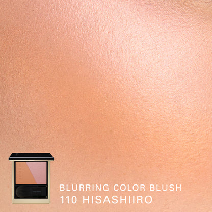 SUQQU Blurring Color Blush 110 Hisashiiro, golden orange and pink blush and highlighter palette open with model cheek colour swatch close up