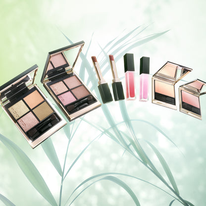 SUQQU 2026 Pre-Summer Collection beautiful luxury makeup products on green leaves background.