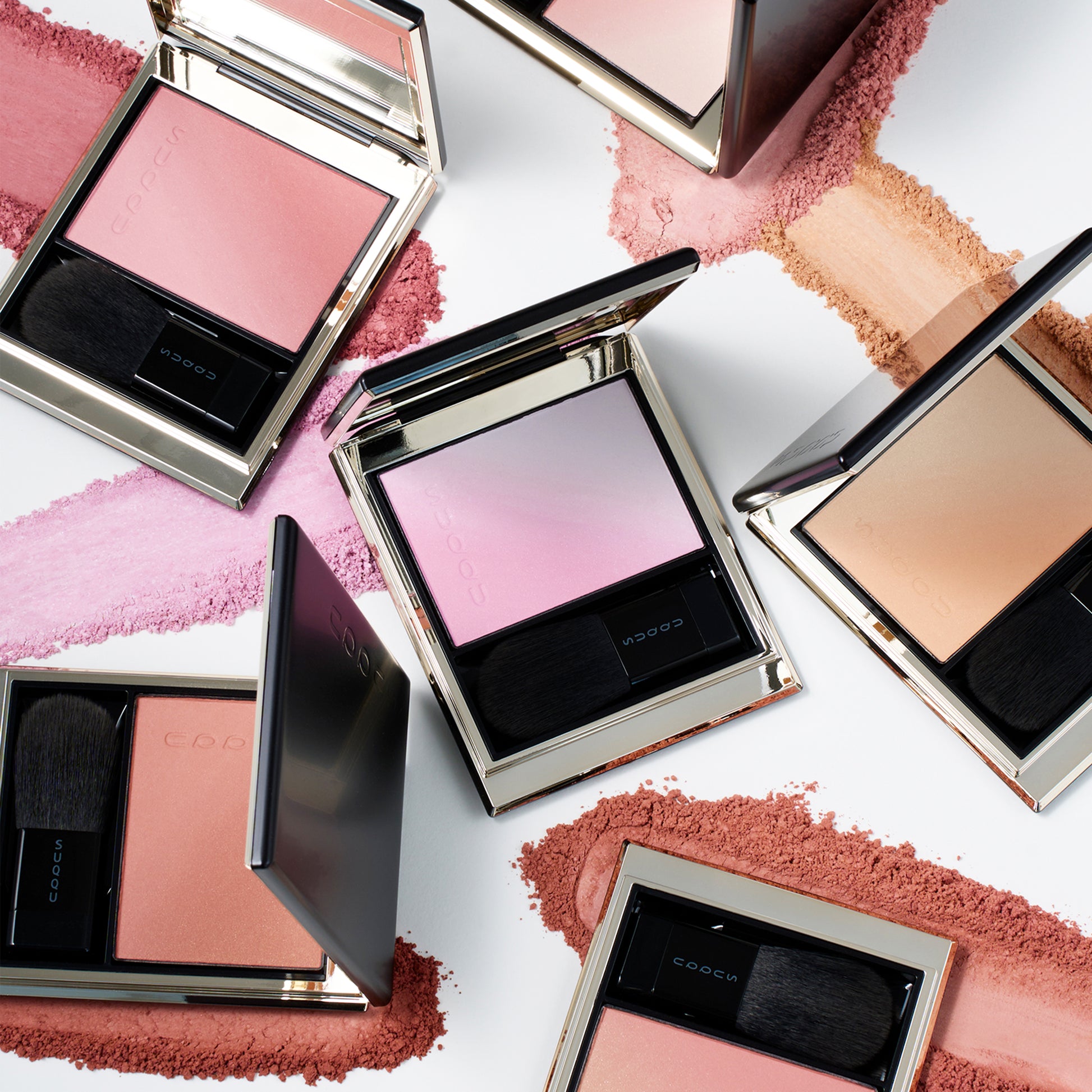 Six colourful SUQQU Blurring Color Blush palettes sitting on a table with powder swatch textures.
