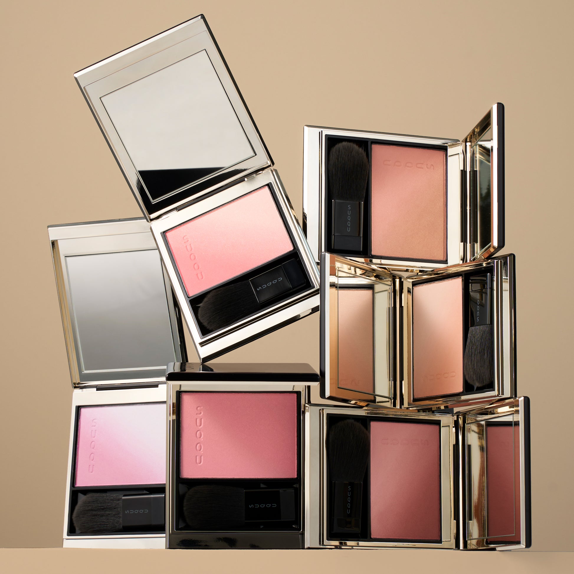 Six colourful SUQQU Blurring Color Blush palettes stacked on a table.