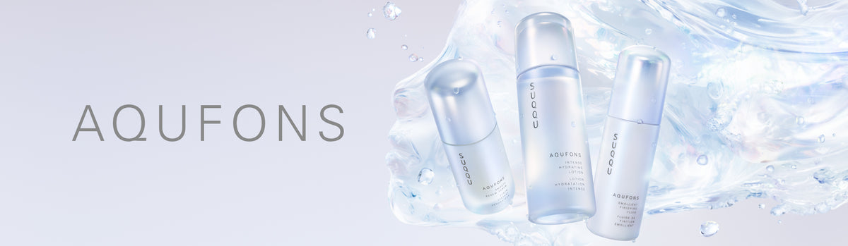 Three clear cosmetic pump bottles from the Japanese luxury skincare range AQUFONS, set against a dynamic splash of icy blue water on a light gray background.