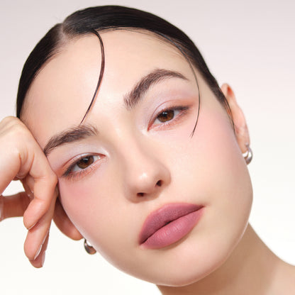 Model portrait with head resting on hand showing eye make up from SUQQU Signature Color Eyes 156 eyeshadow. Cheek blusher from Blurring Colour Blush 10 and lipstick from Blur Liquid Lip 02.