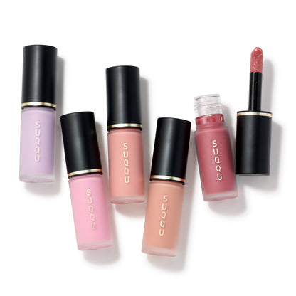 Five SUQQU Complexion Face Color products lying on a table, with one cap off to show wand applicator.