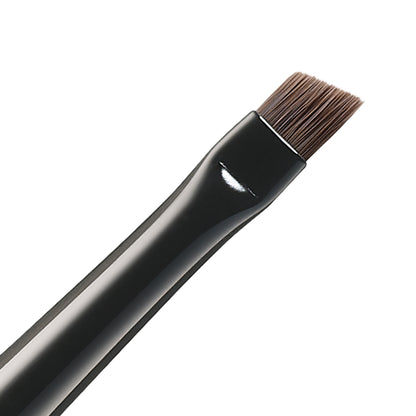 SUQQU Eyebrow Brush Small Japanese synthetic artisan professional grade make up brush bristle close up on plain background.
