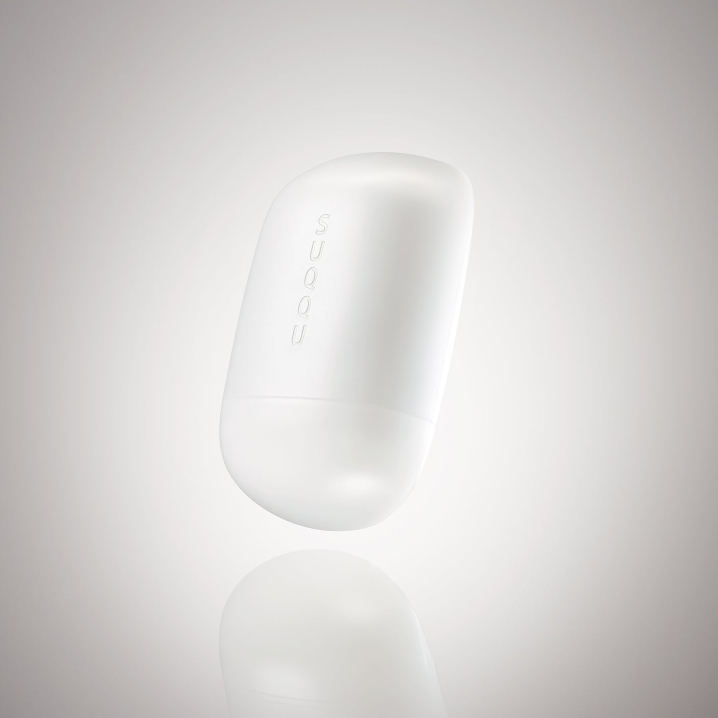 SUQQU Glowing Balm product floating on a soft grey background.