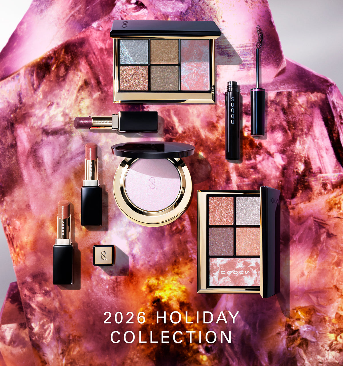 A flat-lay collection of SUQQU luxury Christmas Gift makeup products including eyeshadow and blusher combination palettes, lipsticks and mascara, arranged on a sparkling pink crystal background with the text '2026 HOLIDAY COLLECTION'.