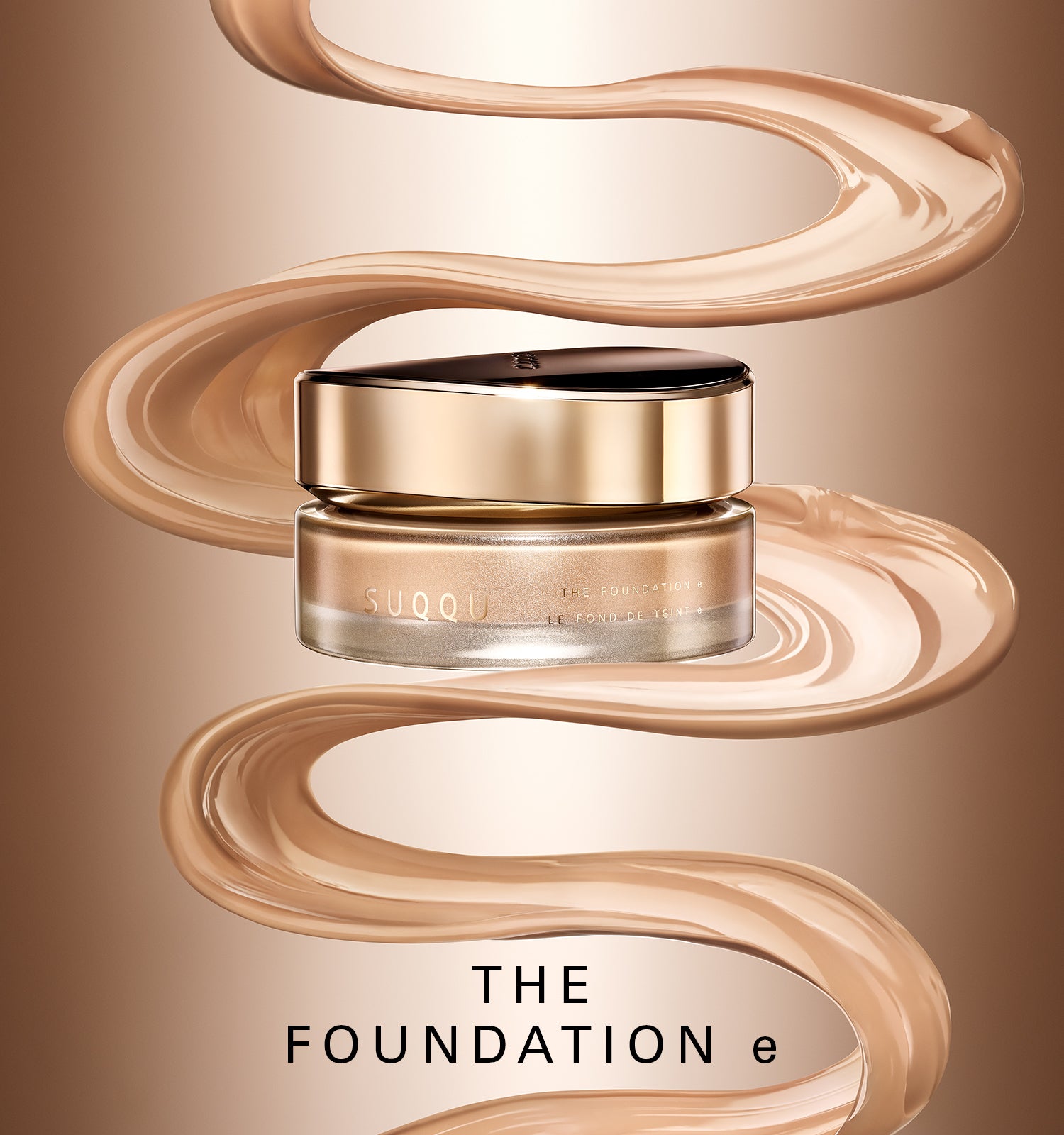 A jar of SUQQU 'The Foundation e' luxury foundation cream is centered against a warm beige gradient background, surrounded by elegant, flowing swirls of the beige foundation cream itself. The jar has a metallic gold lid and a clear glass base showing the cream inside.