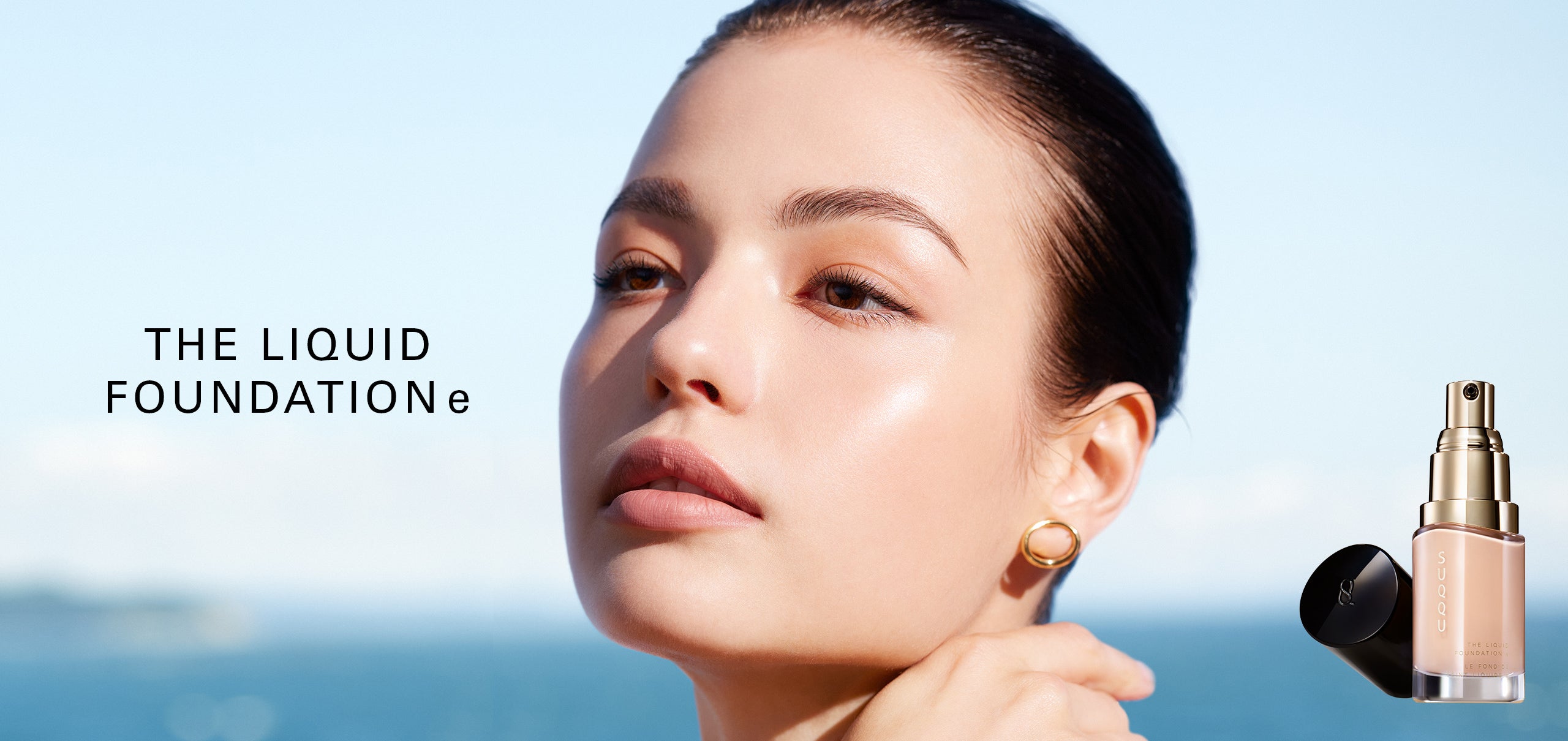 SUQQU The Liquid Foundation e model portrait wearing foundation to show the high-quality smooth and flawless skin finish. Shown with one foundation product with cap off.