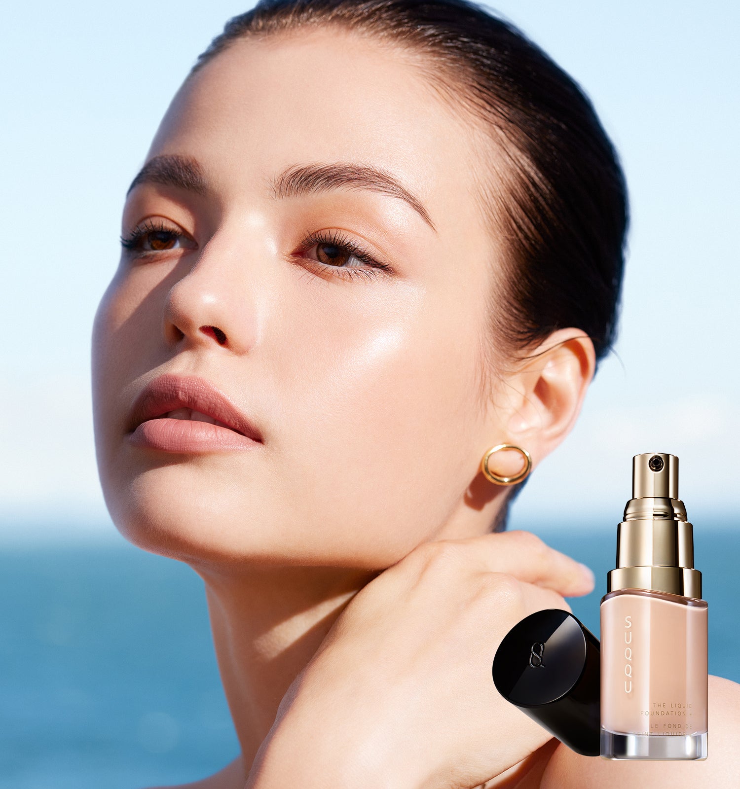 SUQQU The Liquid Foundation e model portrait wearing foundation to show the high-quality smooth and flawless skin finish. Shown with one foundation product with cap off.