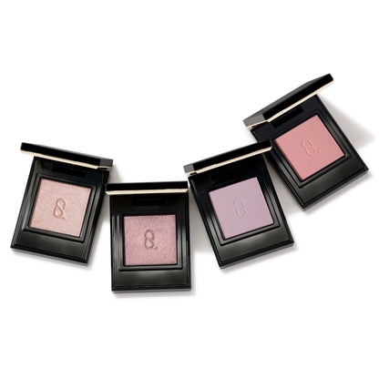 Four beautiful SUQQU Mono Look Eyes single luxury eyeshadow palettes open on a table. In pale soft pink and purple, satin shimmer and matte finishes.