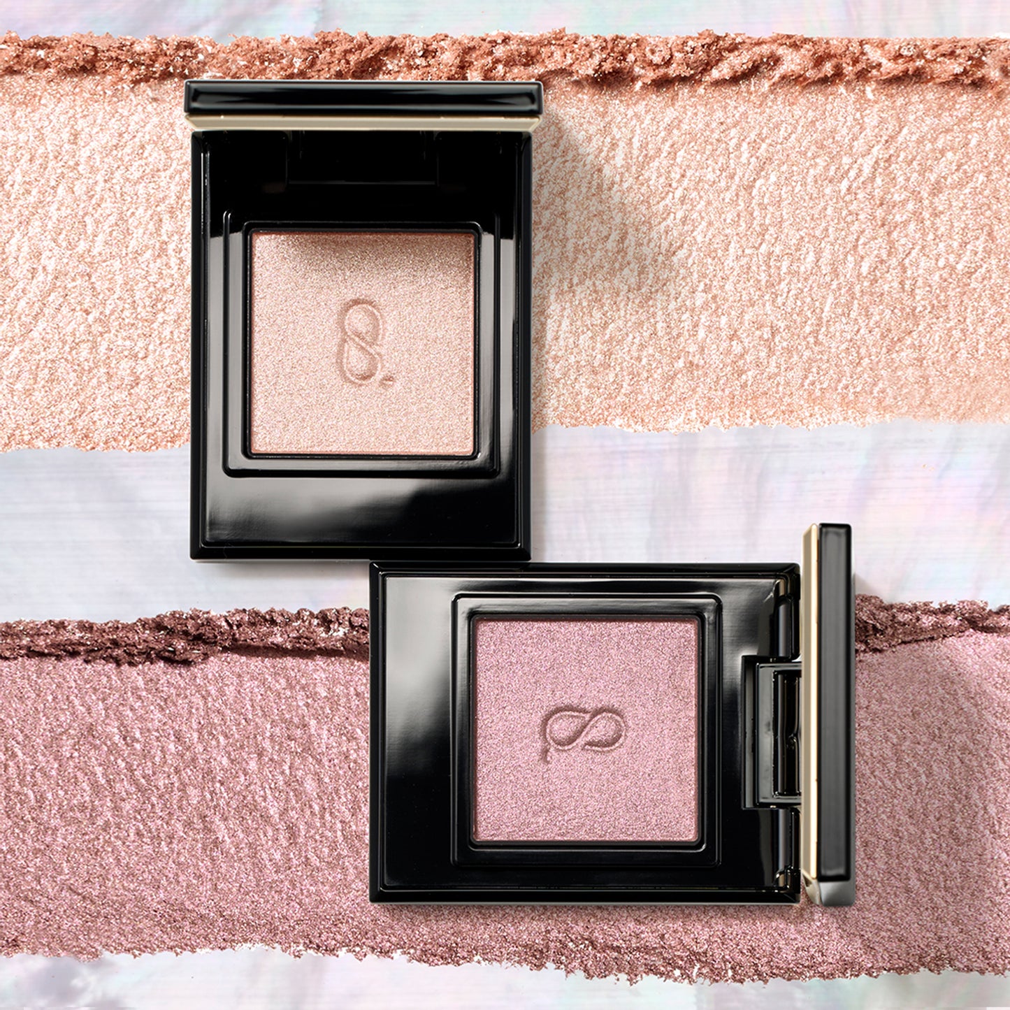 Two glittering SUQQU Mono Look Eyes single luxury eyeshadow palettes in pink gold S-102 and smoky pink purple S-103 colours with texture swatch background.