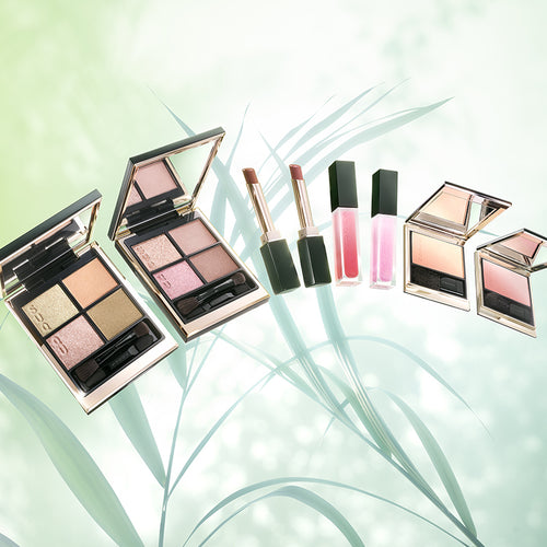 SUQQU 2026 Pre-Summer Collection beautiful luxury makeup products on green leaves background.