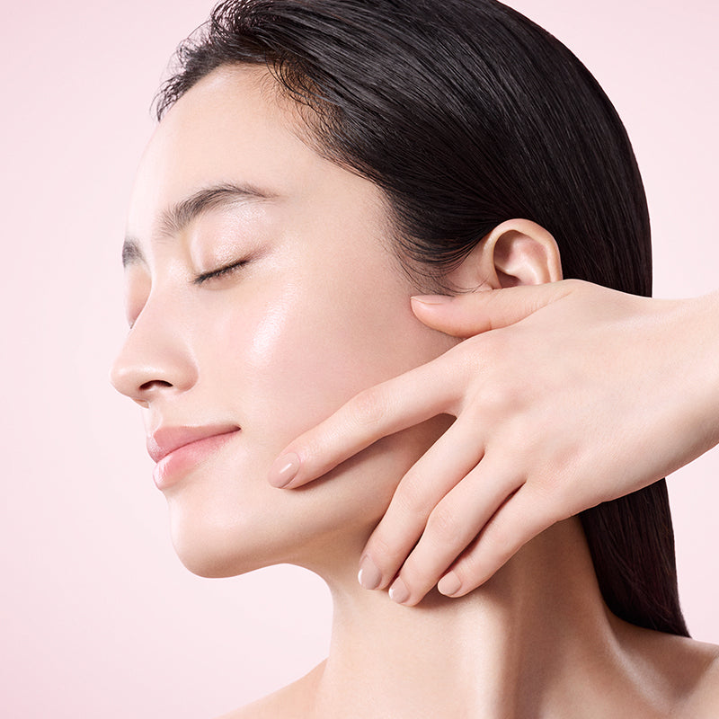 SUQQU Gankin Massage™ model in profile peforming massage step with one hand on her cheek.