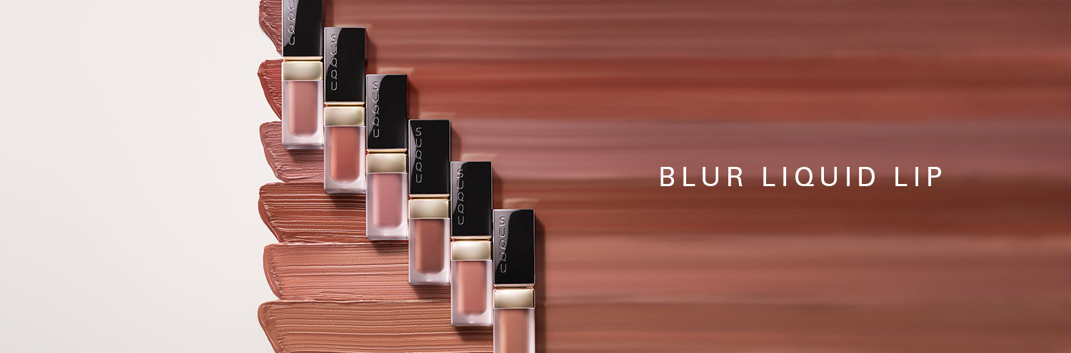 SUQQU Blur Liquid Lip. Six lipstick products on colourful cream texture background.