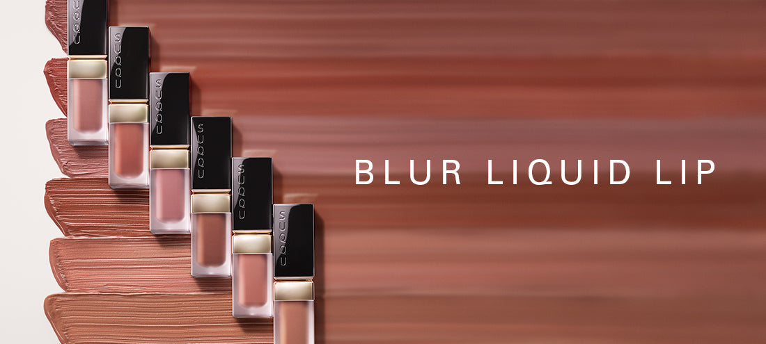 SUQQU Blur Liquid Lip. Six lipstick products on colourful cream texture background.