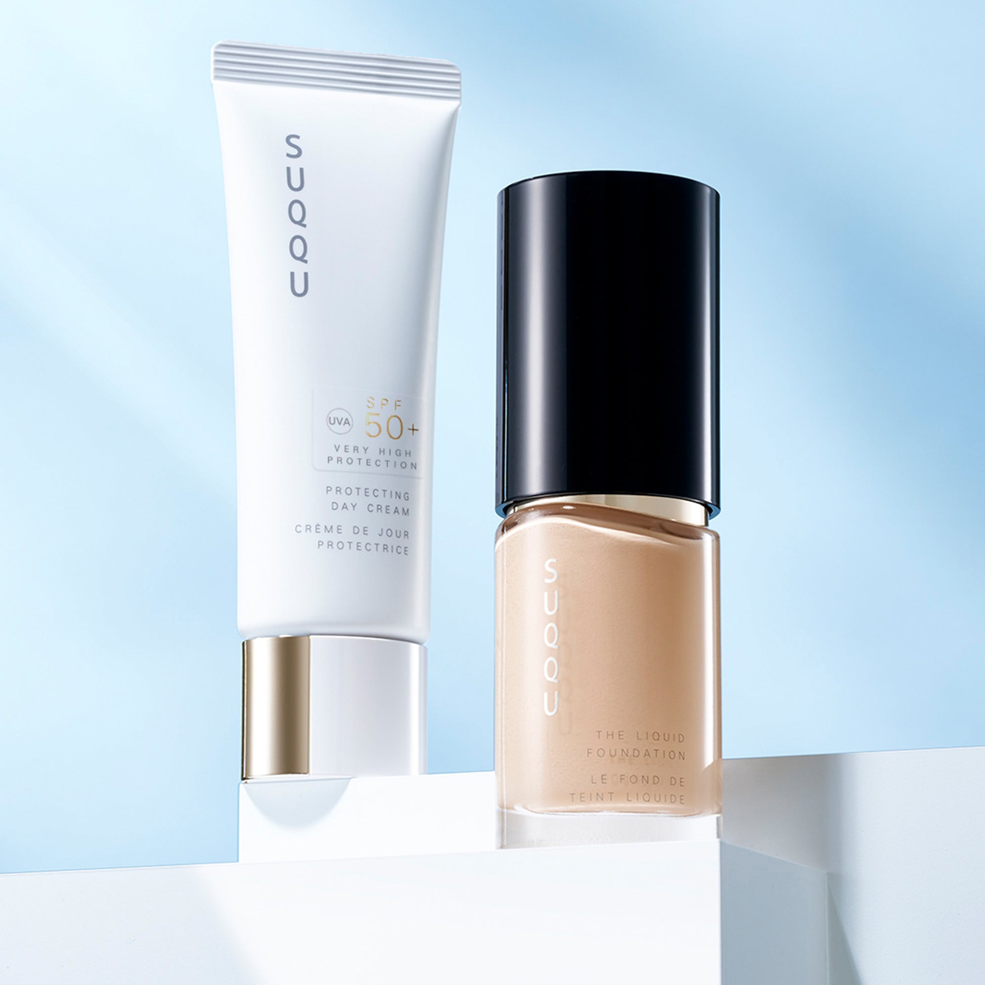 SUQQU Protecting Day Cream SPF50 sunscreen for face tube standing next to foundation tube.