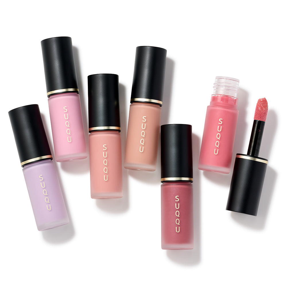 SUQQU Spring Collection 2026 group of six colourful Complexion Face Color makeup tubes lying on a table with one open showing applicator wand.