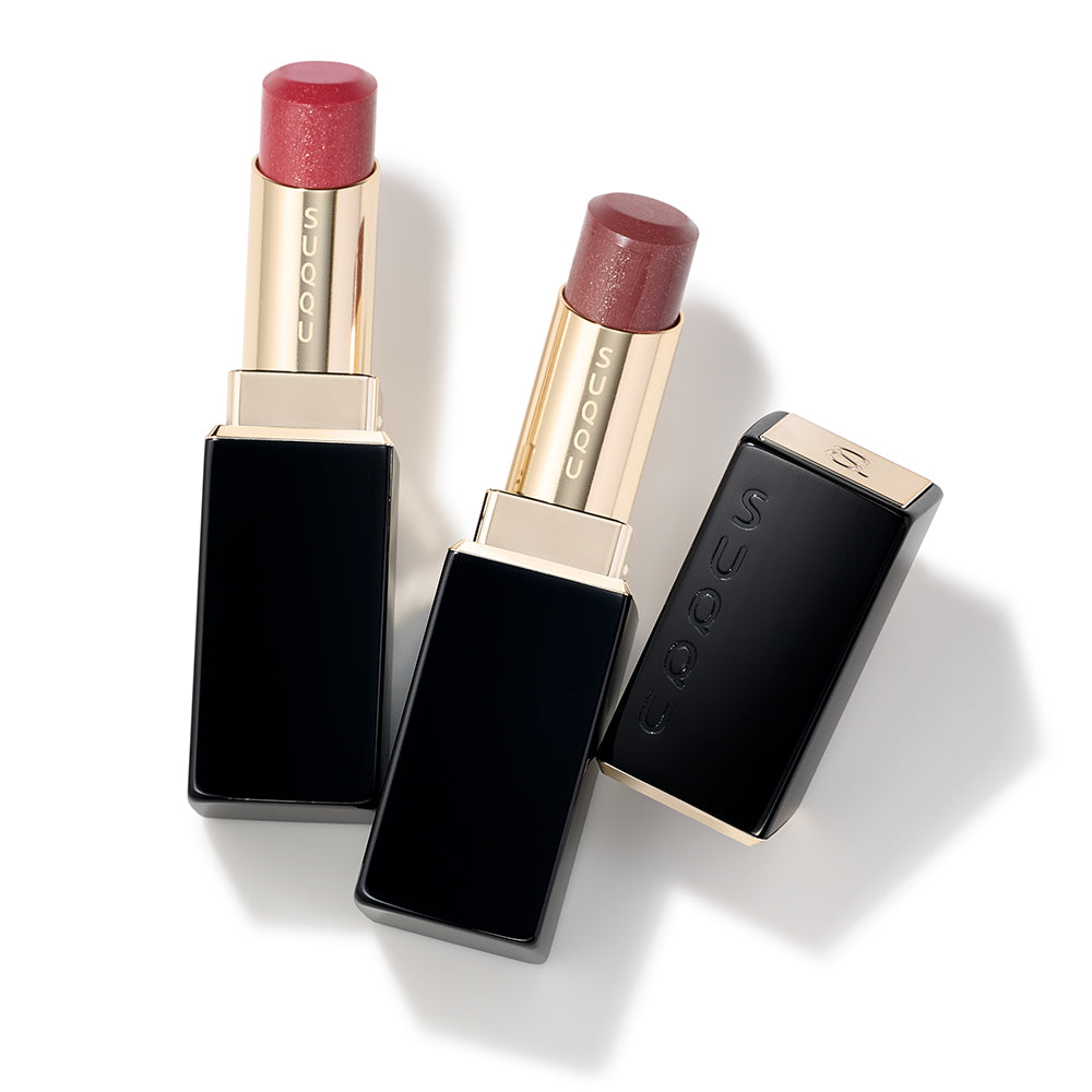 SUQQU Spring Collection 2026 Moisture Glaze Lipstick 110 and 111 makeup lipsticks shown with lid off on a table next to single cap.