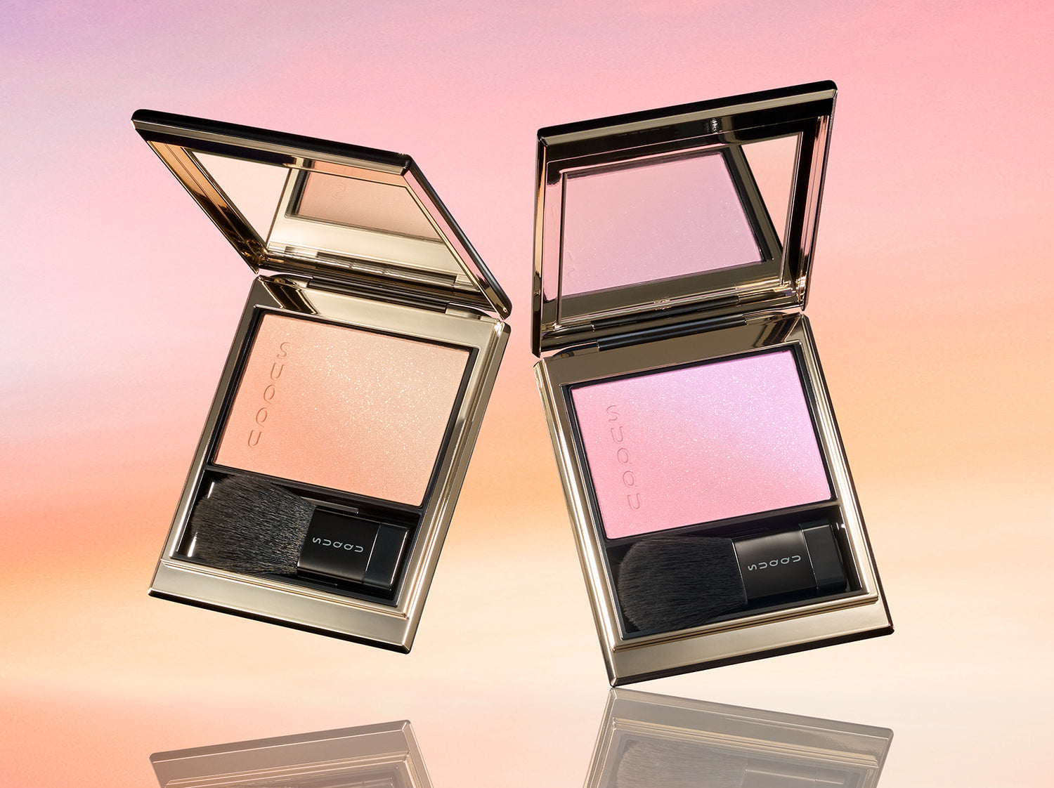 SUQQU 2026 Summer Collection Blurring Color Blush 116 & 117 duo toned cheek blusher and highlighter palettes open on a sunset sky background. Including one gorgeous golden toned palette and pretty pink lavender palette. Discover some of the very the best cheek blushers from Japan at SUQQU.