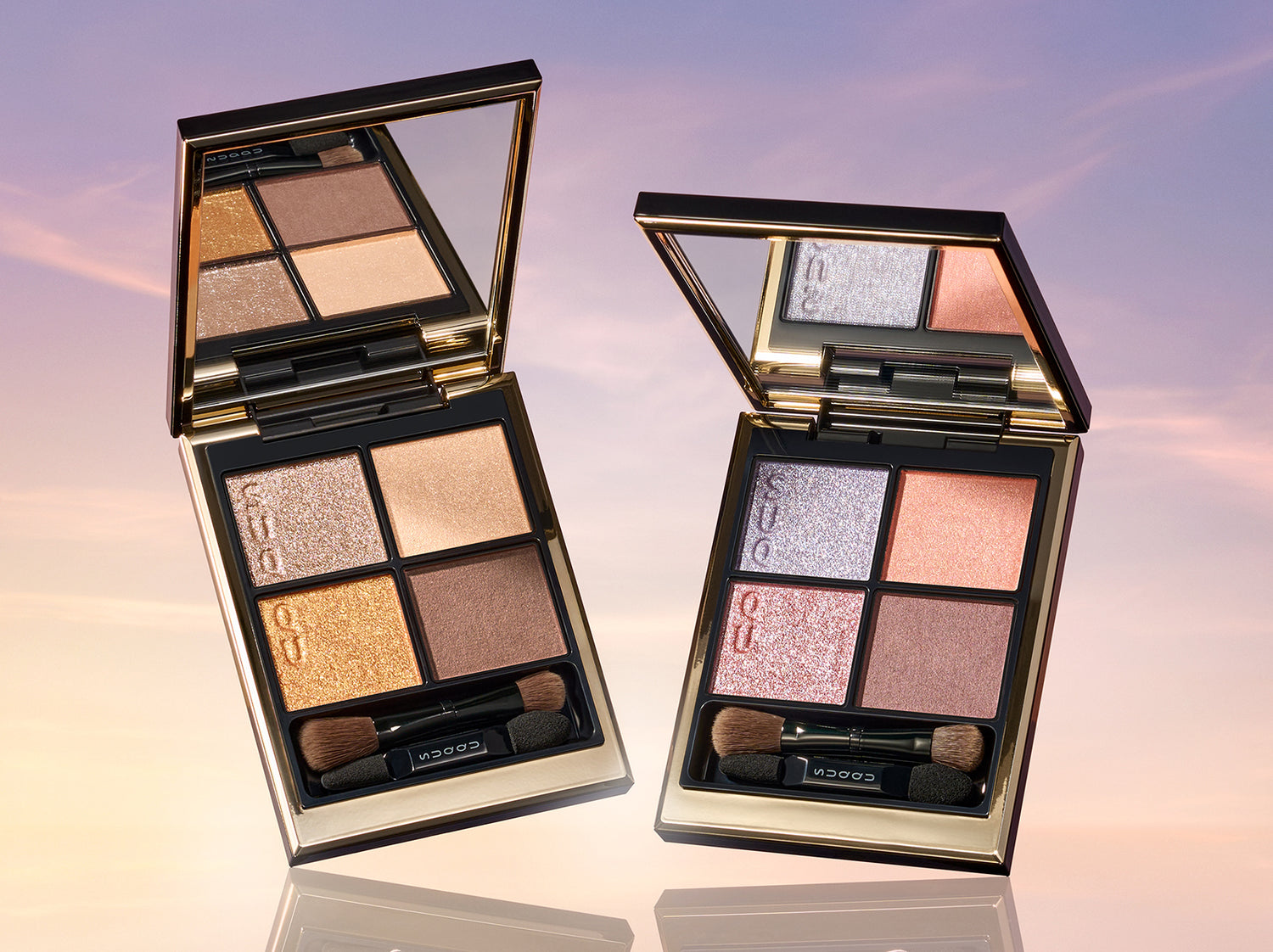 SUQQU 2026 Summer Collection Signature Color Eyes 154 & 155 quad eyeshadow palettes open on a sunset sky background. Including one beautiful  shimmering golden brown toned quad and sparkling blue and pink quad. Discover some of the very the best eyeshadows from Japan at SUQQU.