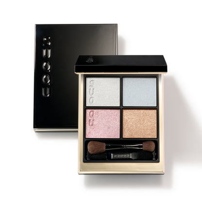 SUQQU Signature Color Eyes 156 glittering quad luxury eyeshadow palette on white background with closed palette lid. Soft pink, blue and gold shades with fine shimmering pearl white highlighter.