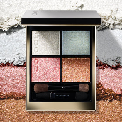 SUQQU Signature Color Eyes 156 gorgeous quad eyeshadow palette on creamy texture colour swatch background. Pale pink, blue and gold shades with shimmering pearl white highlighter.