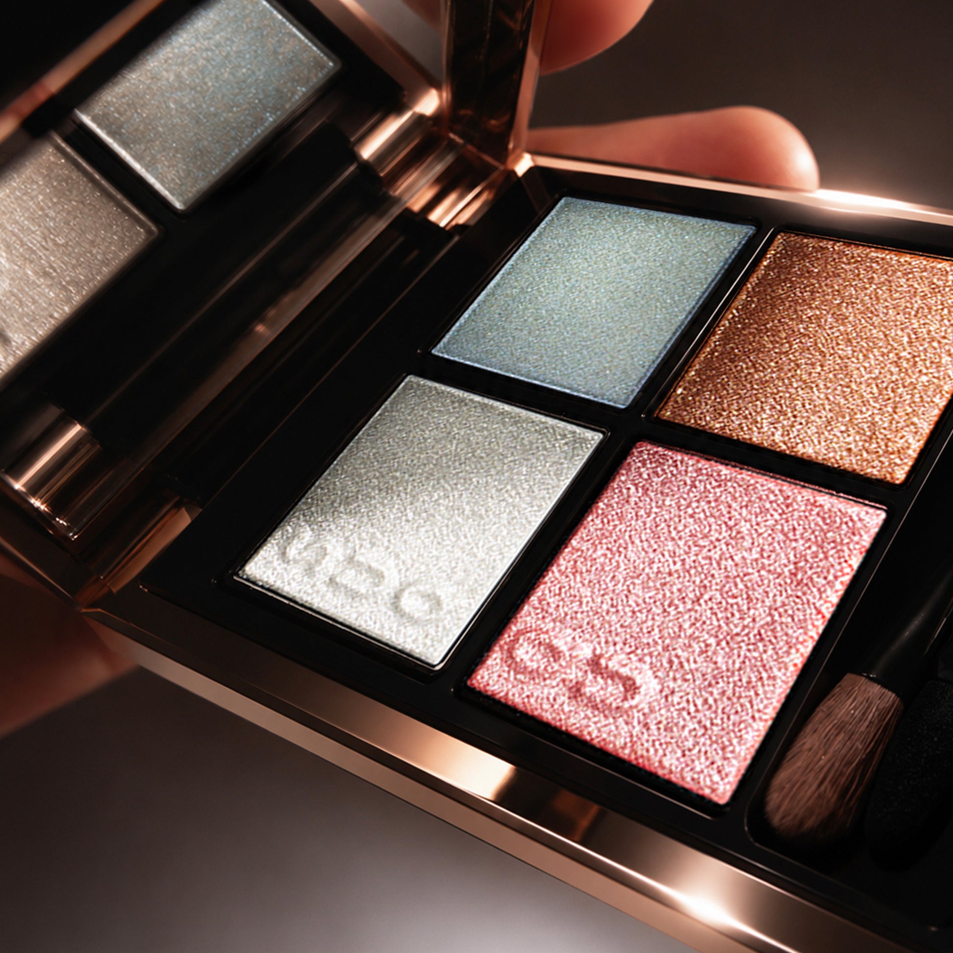 Close up of SUQQU Signature Color Eyes 156 beautiful quad eyeshadow palette with luxury skincare ingredients opened in creamy pearl soft pink, blue and gold shades. With the finest sparkling pearl white highlighter.